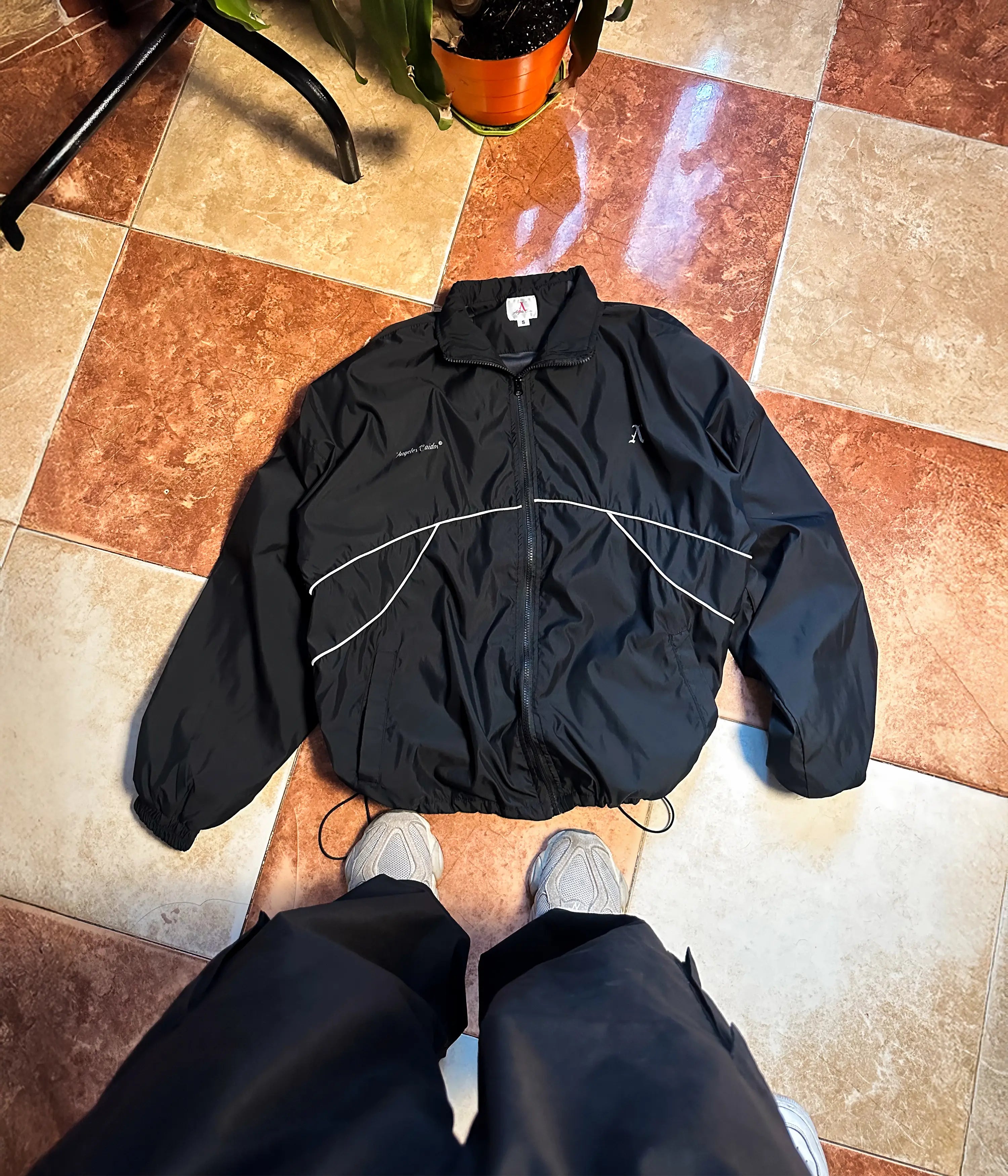 Chaqueta deportiva negra con líneas blancas